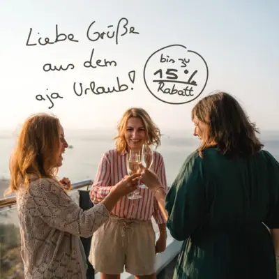 Eine Gruppe von Frauen steht auf einem Balkon mit einem Glas Wein.