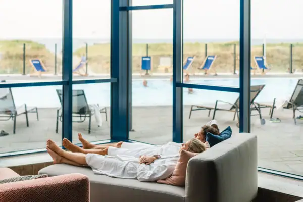 Ein Paar liegt auf einem Sofa.