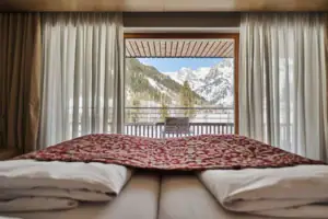 Ein Bett mit Blick auf die Berge durch ein Fenster.