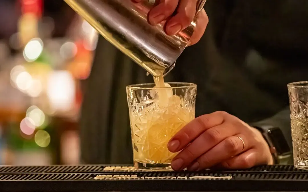 Barkeeper gießt einen Cocktail in ein Glas.