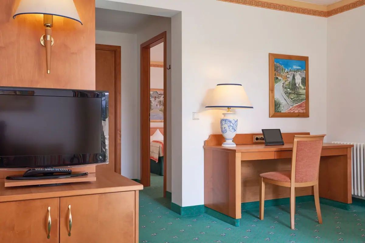 Ein Raum mit einem Schreibtisch und einem Fernseher.