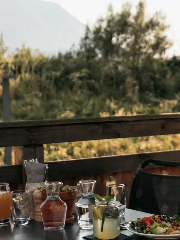 Ein Tisch mit Essen, umgeben von Stühlen und einem Sonnenschirm.