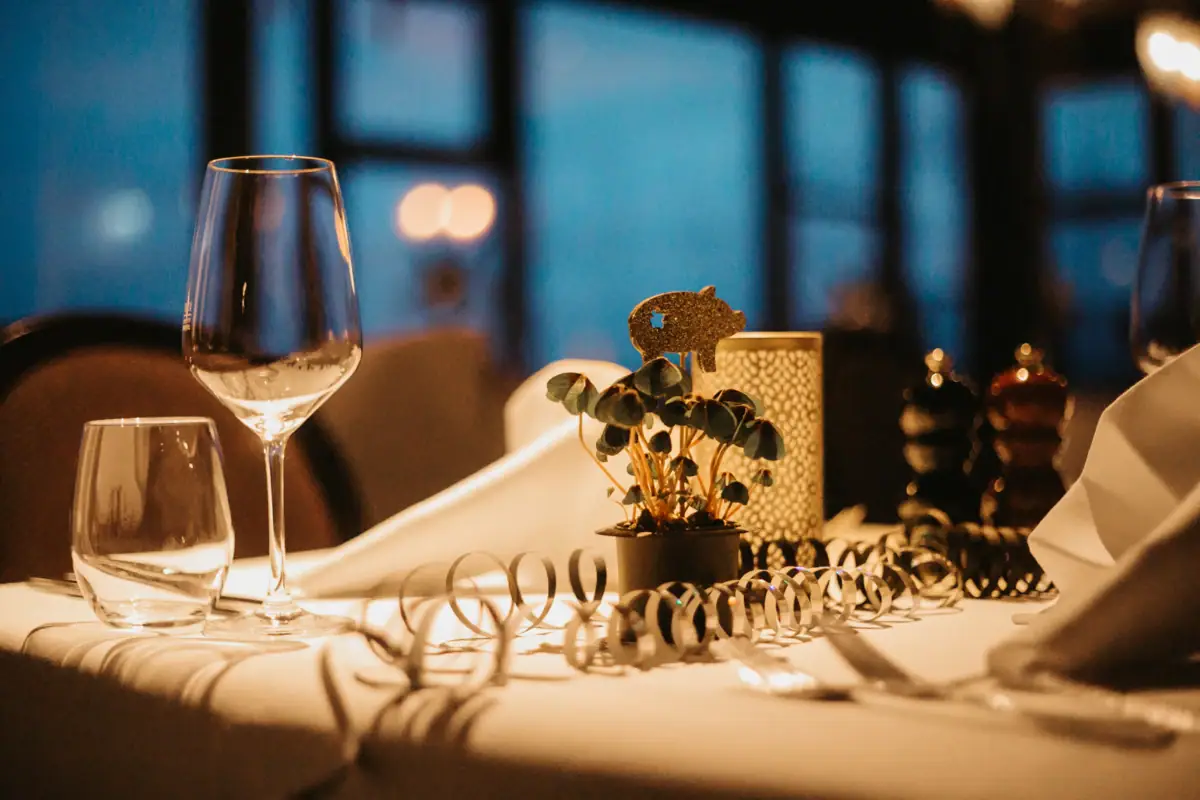 Ein Tisch mit einem Weinglas und einer Pflanze darauf.