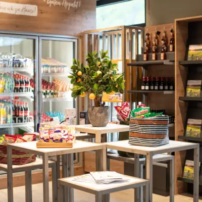 24 h Shop im aja Ruhpolding Ein Tisch mit Essen und einer Pflanze darauf.