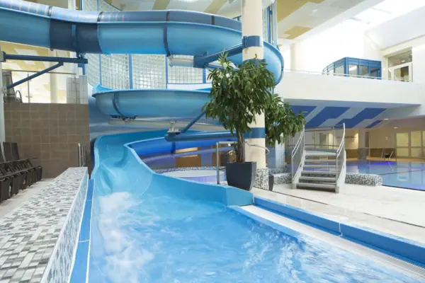 SPA - Grömitz Wasserrutsche in einem Gebäude über einem Schwimmbecken.