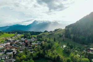 Eine Stadt in einem Tal mit Bäumen und Bergen.