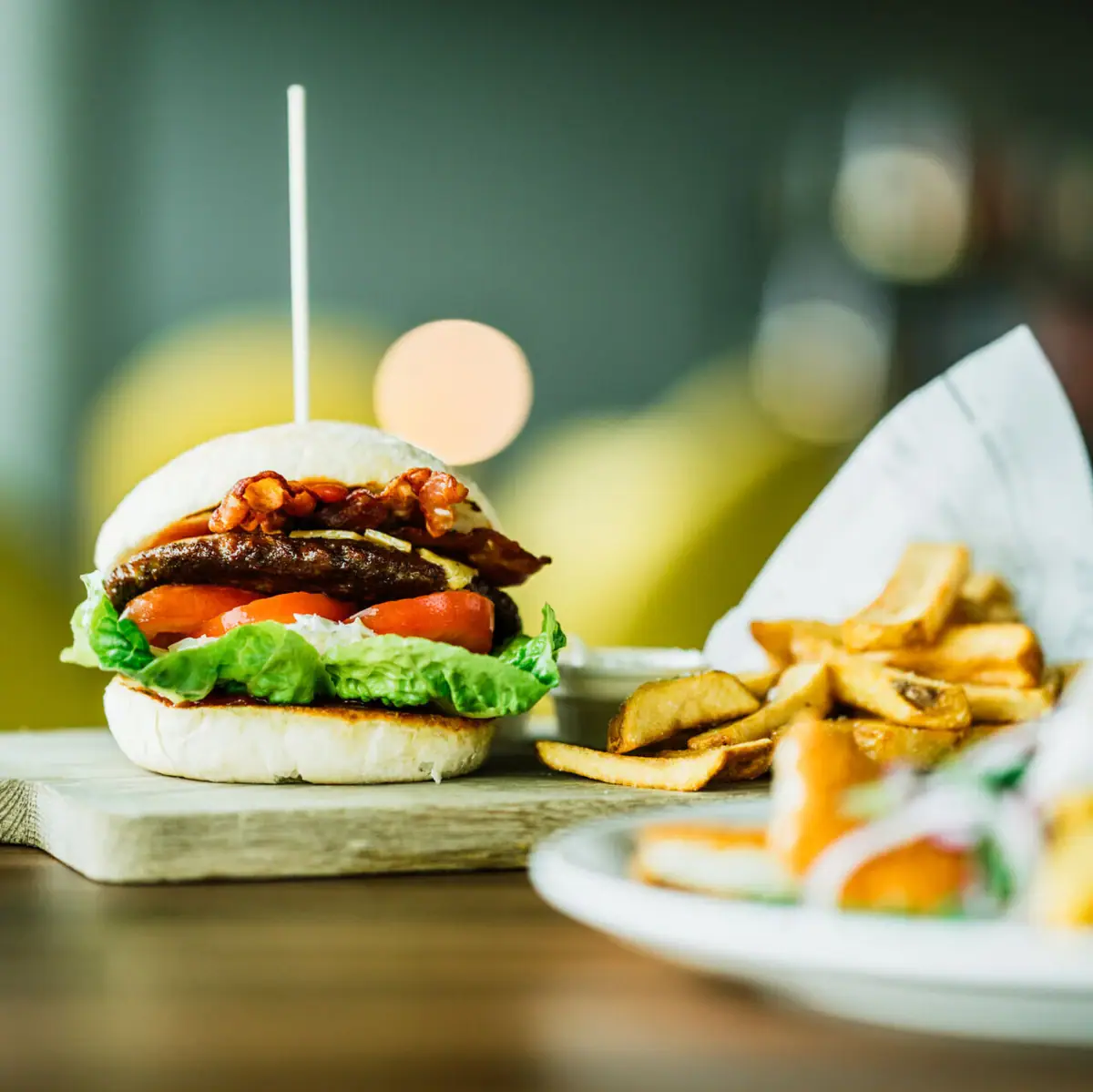 Burger mit Pommes Burger und Pommes auf einem Holzbrett