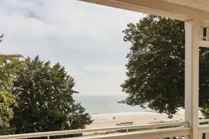 Ausblick Eine Terrasse mit Stühlen und einem Tisch darauf.