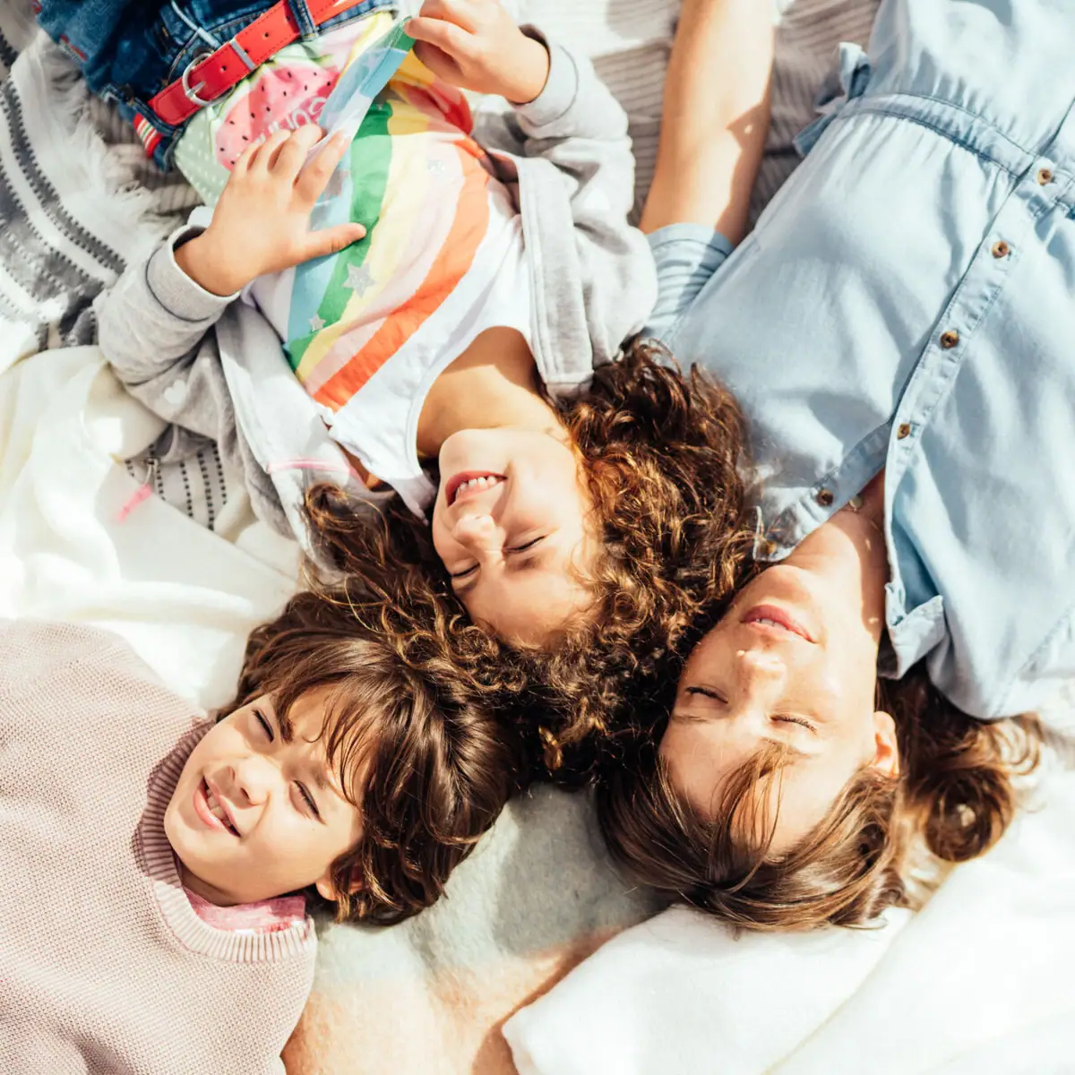 Familie am Strand Eine Gruppe von Personen liegt auf einer Decke.