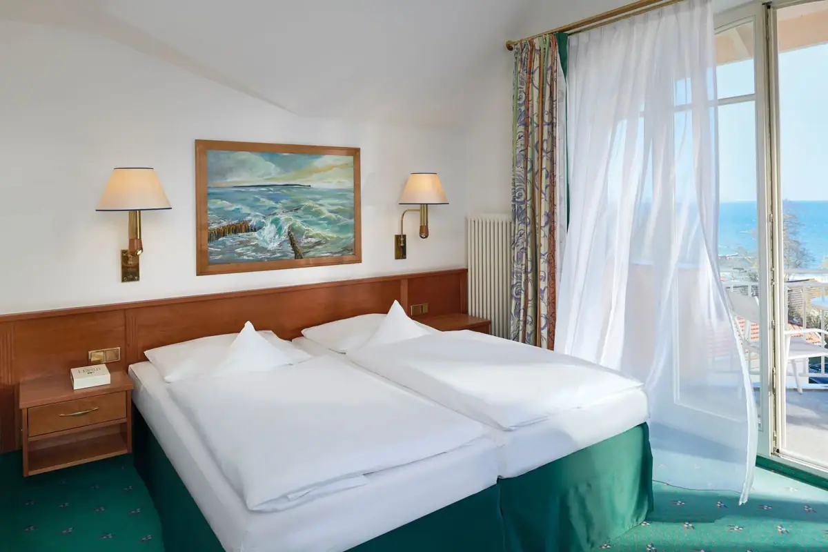 Ein Zimmer mit zwei Betten und einem Fenster.