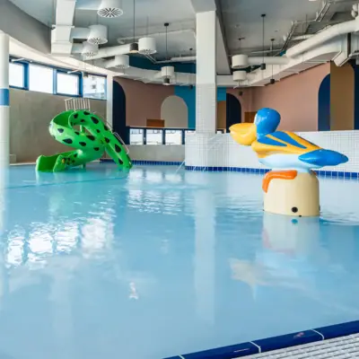 Ein Kinderbecken in einem Schwimmbad mit einer Wasserrutsche.