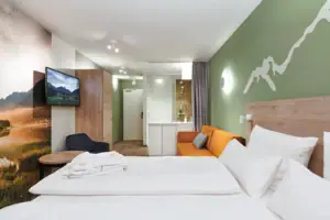 Doppelzimmer aja Ruhpolding Ein Zimmer mit einem Bett und einem Fernseher.