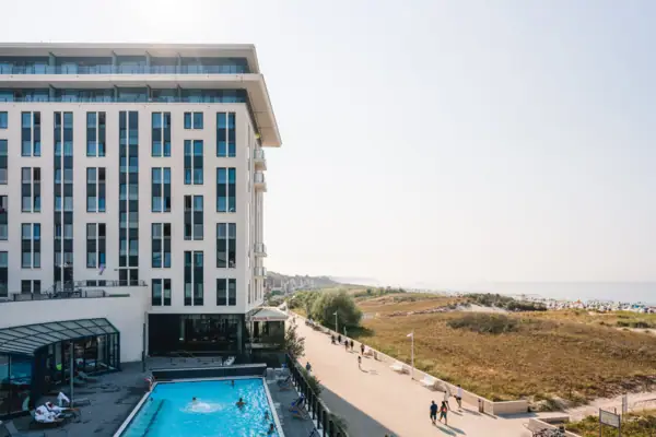 Ein Gebäude mit einem Pool und vorbeigehenden Menschen.