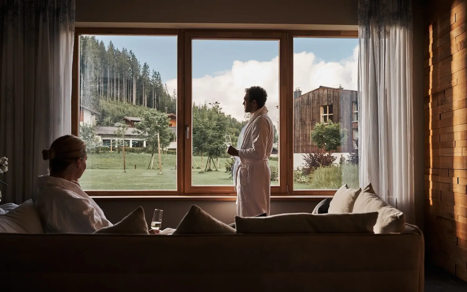 Man in bathrobe standing in front of a window in a wellness area.