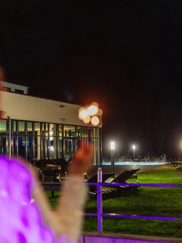 Silvester im aja Bad Saarow Eine Person steht vor dem Hotel und hält Wunderkerzen in der Nacht.