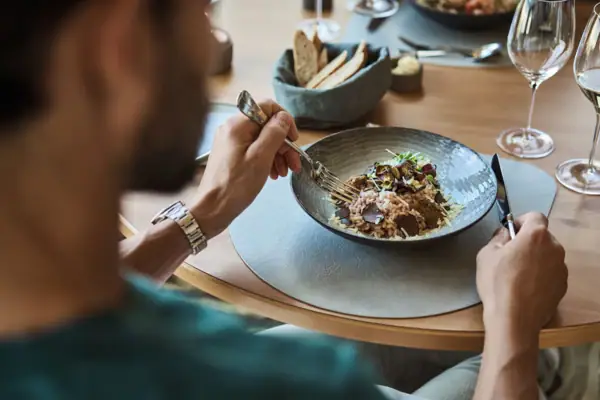 Eine Person isst eine Mahlzeit an einem Tisch.