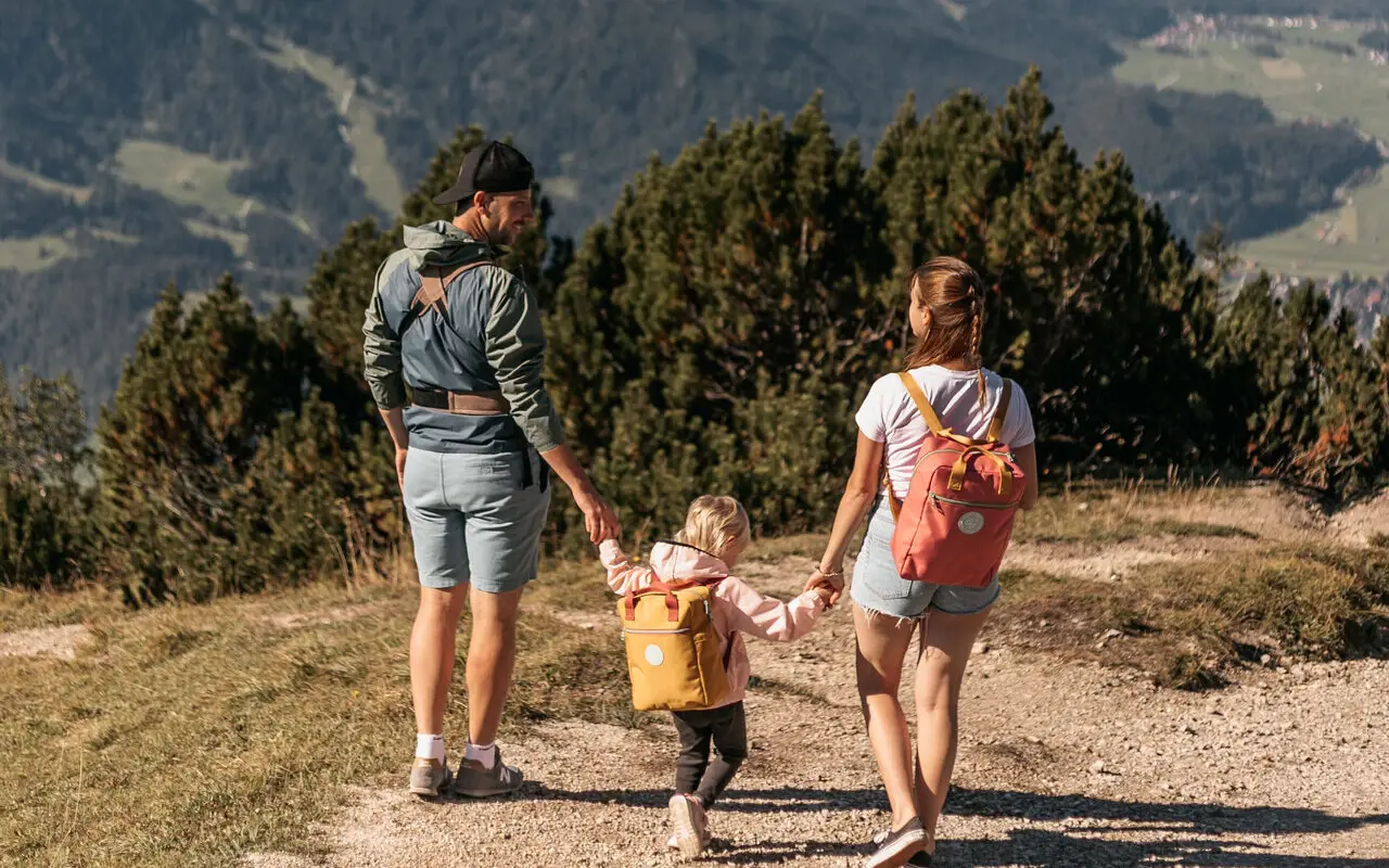 Familie mit Kleinkind beim Wandern auf einem Berg.