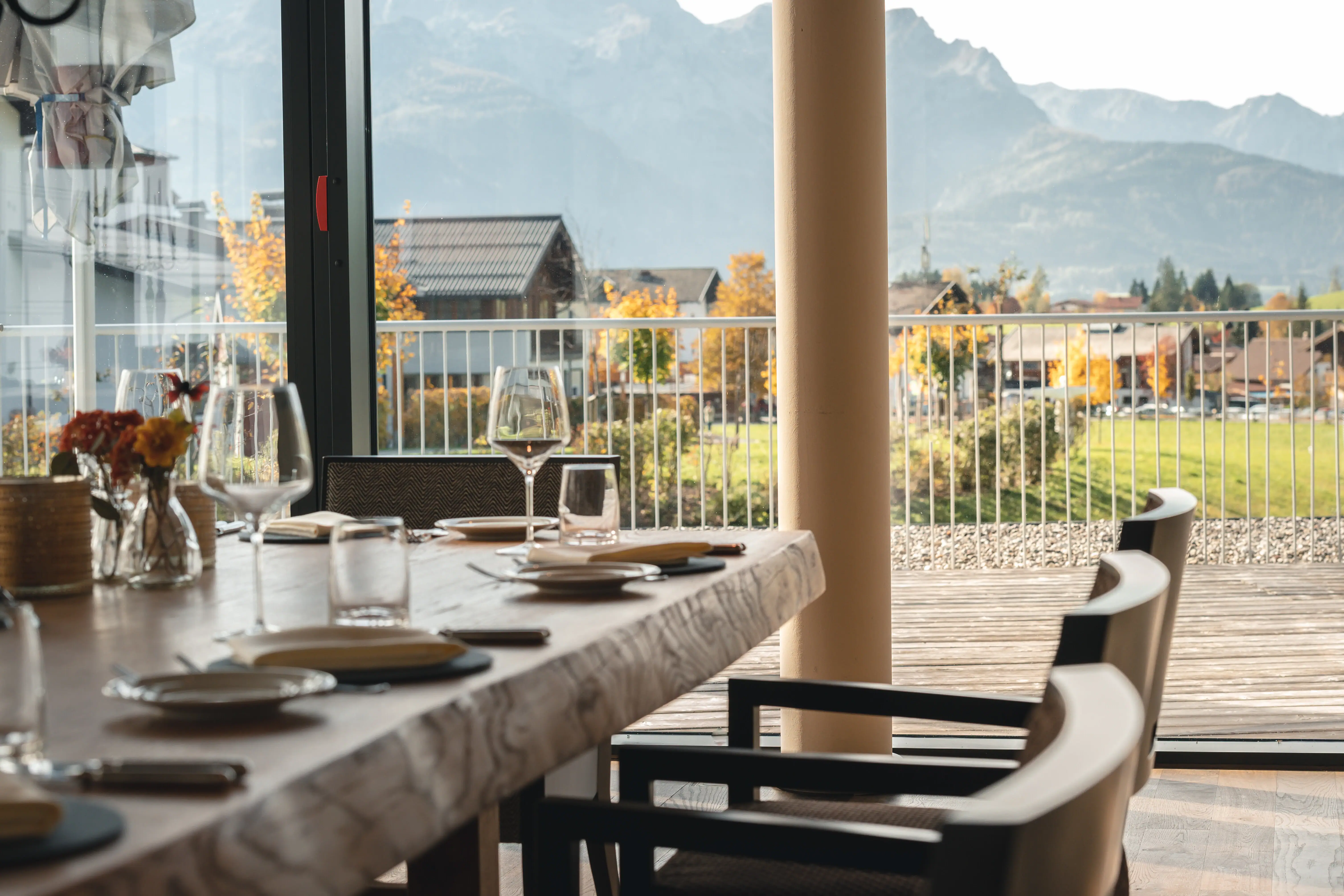 Ein Tisch mit Tellern und Gläsern darauf, in einem Außenbereich.