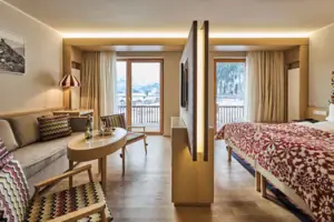 Ein Zimmer mit einem Bett, einem Tisch und Stühlen.