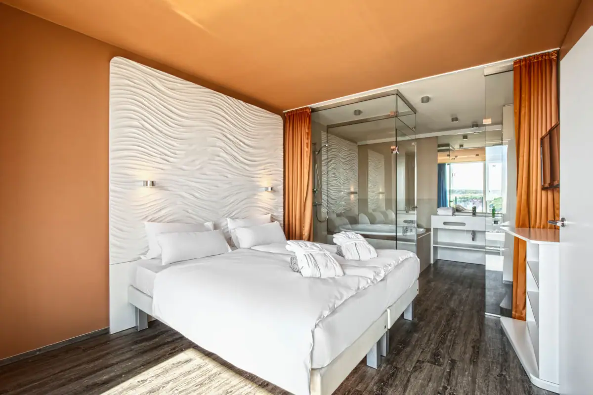 Doppelzimmer mit Bad im aja Warnemünde Zimmer mit Bett und Waschbecken.