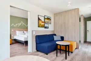 Suite mit Balkon aja Ruhpolding Ein Raum mit einem Sofa und einem Tisch.