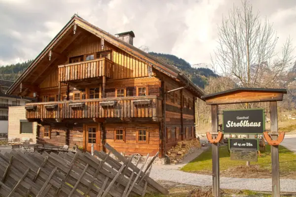 Ein Holzhaus mit einem Schild davor.