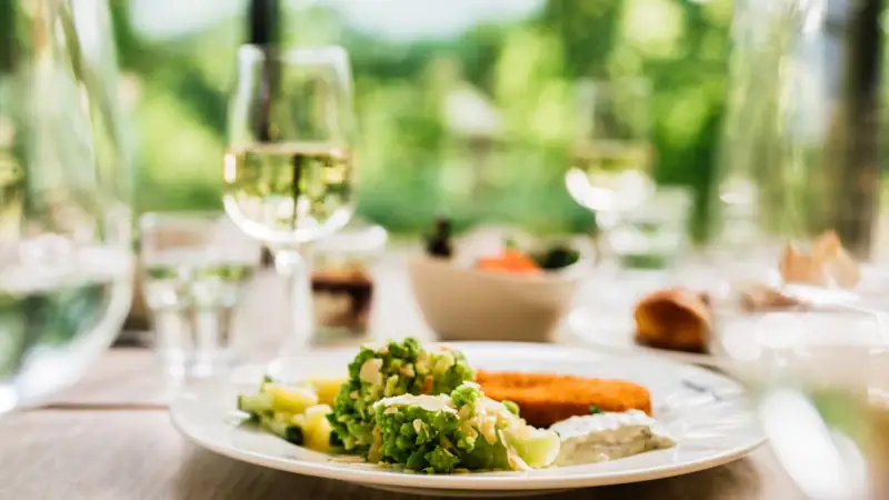 Abendessen im aja Bad Saarow Ein Teller mit Essen und ein Glas Wein.