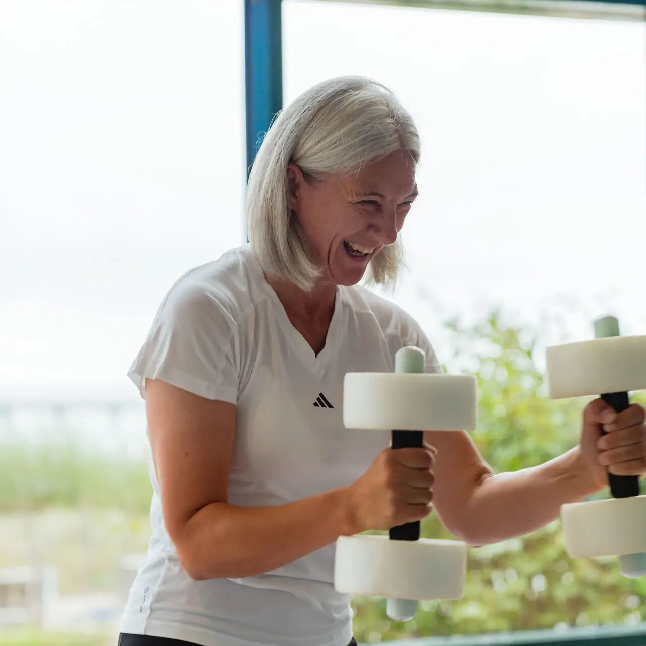 Eine Frau hebt Gewichte im Fitnessstudio.