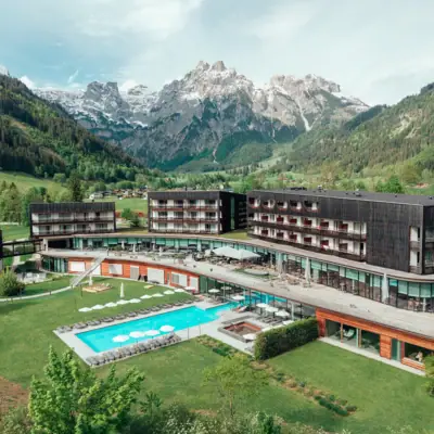 Hotel mit Pool und Bergen im Hintergrund