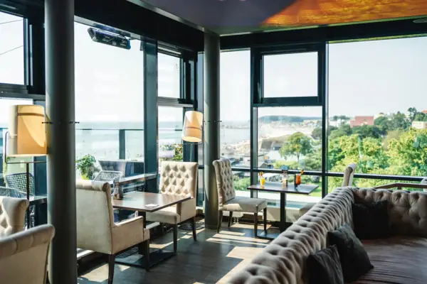 Ein Raum mit einem großen Fenster, Tischen und Stühlen.