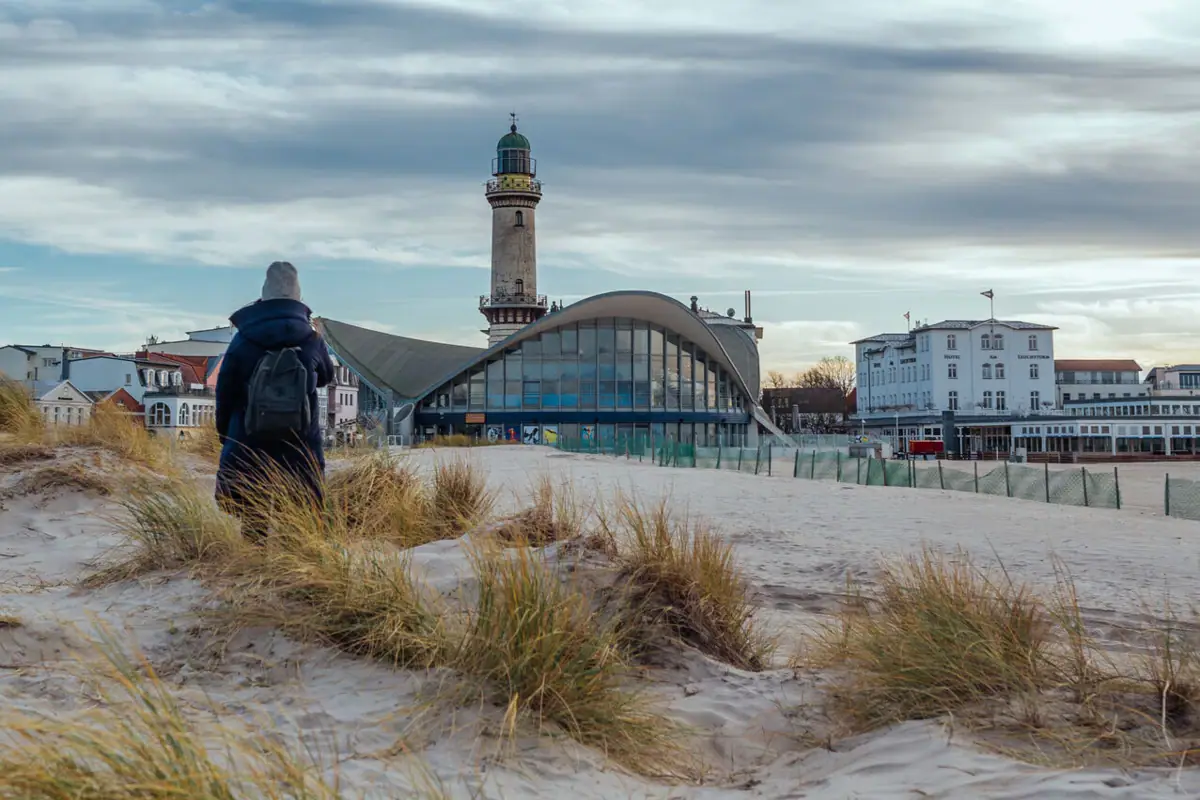 Warnemünde Winter Eine Person, die am Strand spaziert.