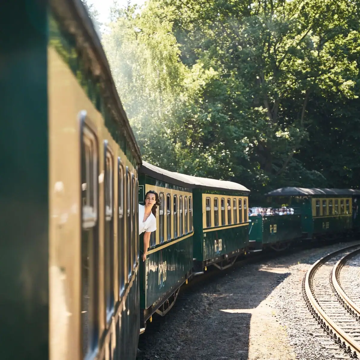 Eine Frau lehnt sich aus einem Zugfenster.
