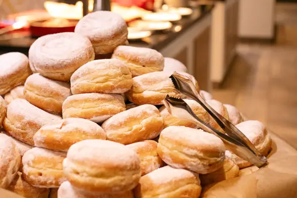 Mitternachtsimbiss im aja Ruhpolding Ein Stapel Pfannkuchen mit Puderzucker.