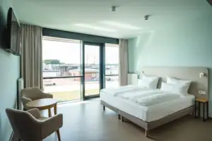 Behindertenfreundliches Zimmer Ein Schlafzimmer mit einem Bett und Stühlen.