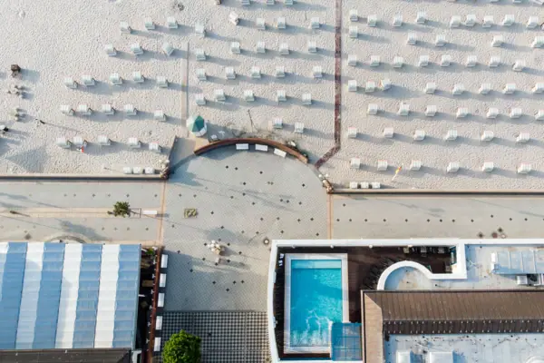 Strand mit vielen Stühlen und einem Pool im Freien.