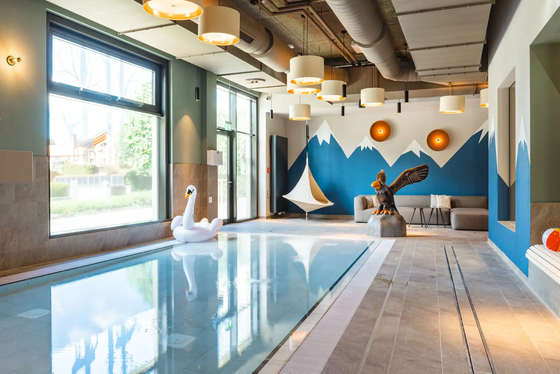 Kinderpool Ein Schwimmbecken mit einer Schwanen- und einer Vogelskulptur.