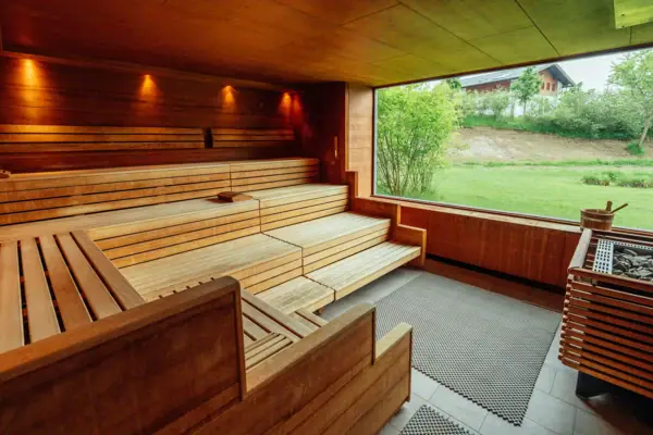 Panoramasauna Holzsauna mit Fenster und Gras im Vordergrund