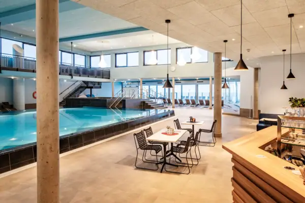 Ein Innenpool in einem Gebäude mit Decke und Möbeln.