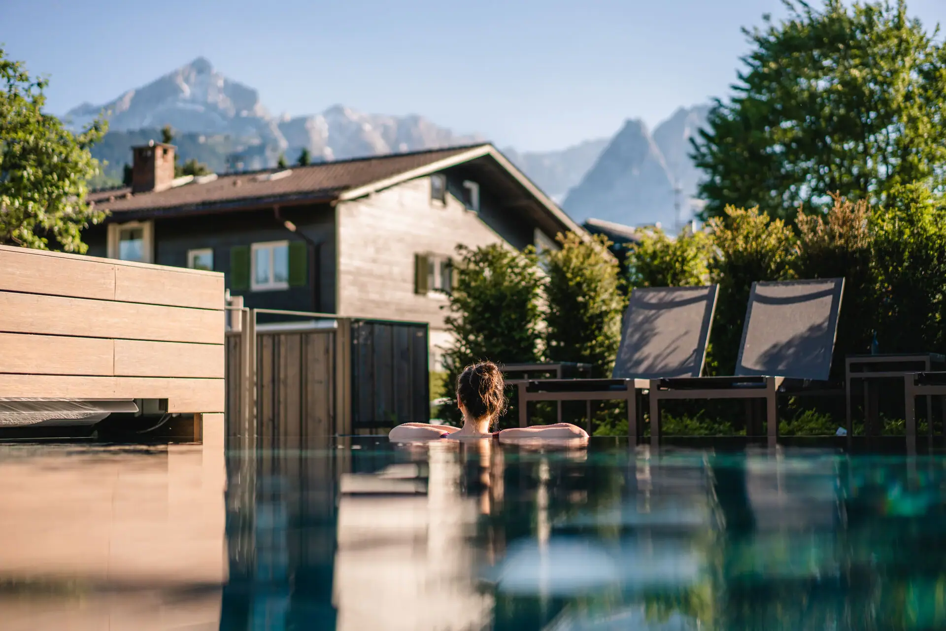 Eine Person im Schwimmbecken mit Bäumen im Hintergrund.