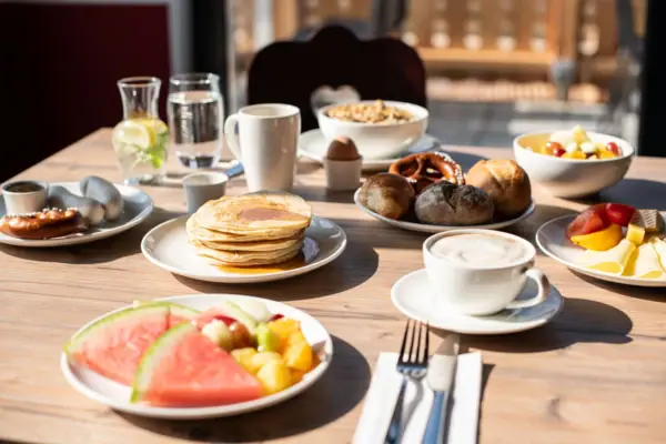 Frühstück im aja Ruhpolding Ein Tisch mit Tellern voller Speisen und Getränken.