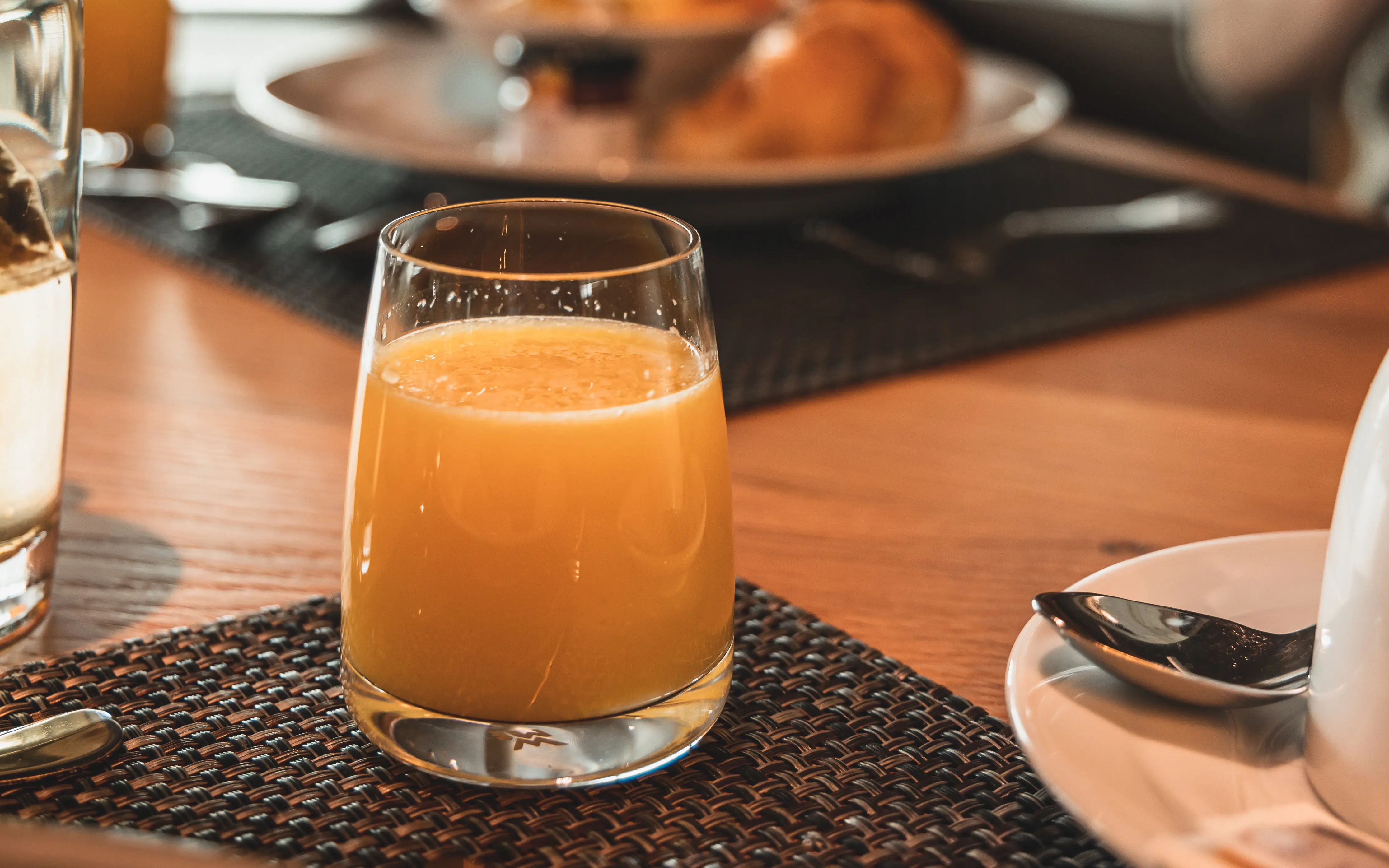 Ein Glas Orangensaft auf einem Tisch.