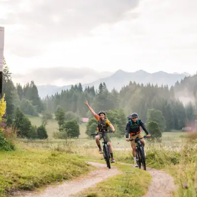 Zwei Personen fahren mit Fahrrädern auf einem Pfad.