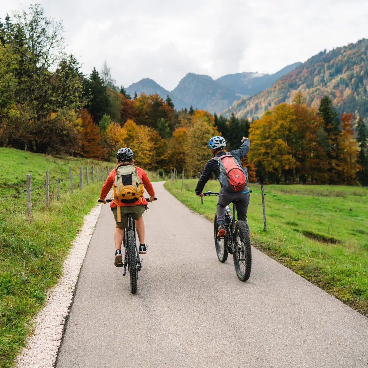 Aktivurlaub in Ruhpolding Zwei Personen fahren auf einer Straße Fahrrad.