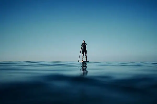 Eine Person auf einem Paddleboard im Ozean.