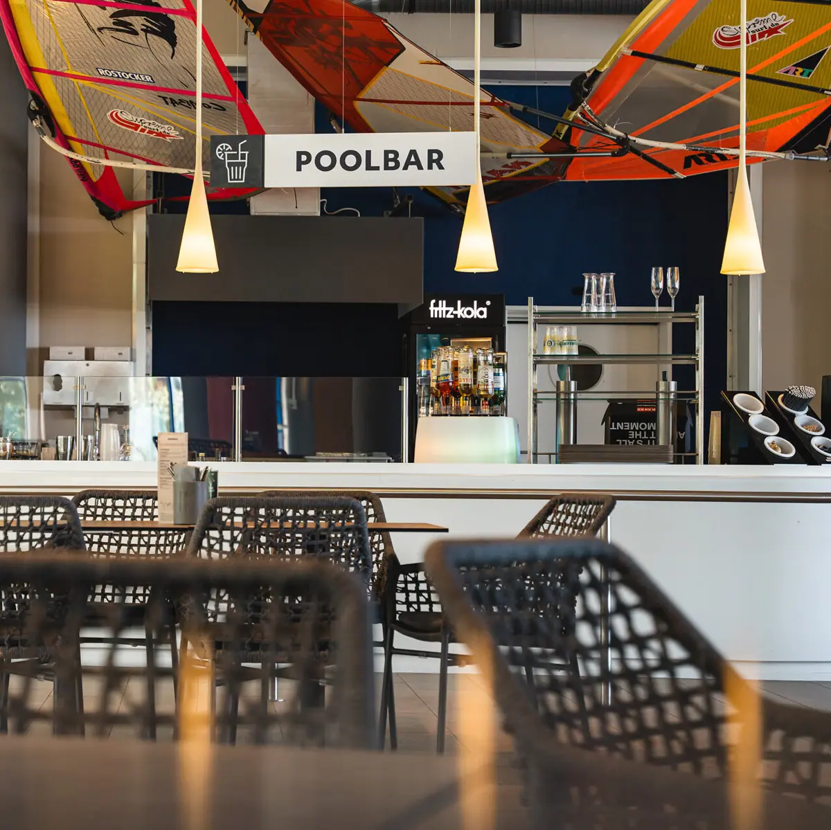 Poolbar Ein Barbereich mit Tischen und Stühlen.