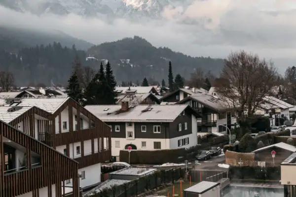 Eine Gruppe von Häusern vor schneebedeckten Bergen.