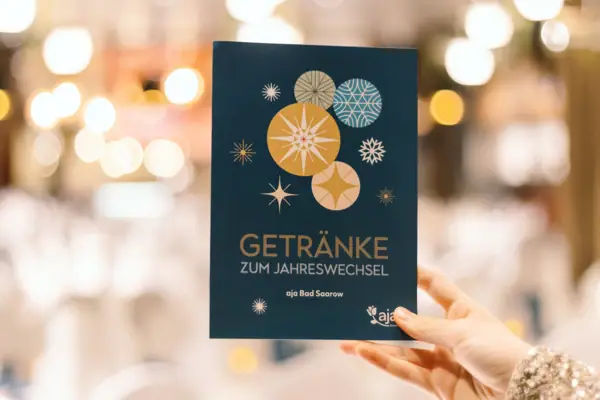 Hand hält eine blaue Karte auf der Getränke steht