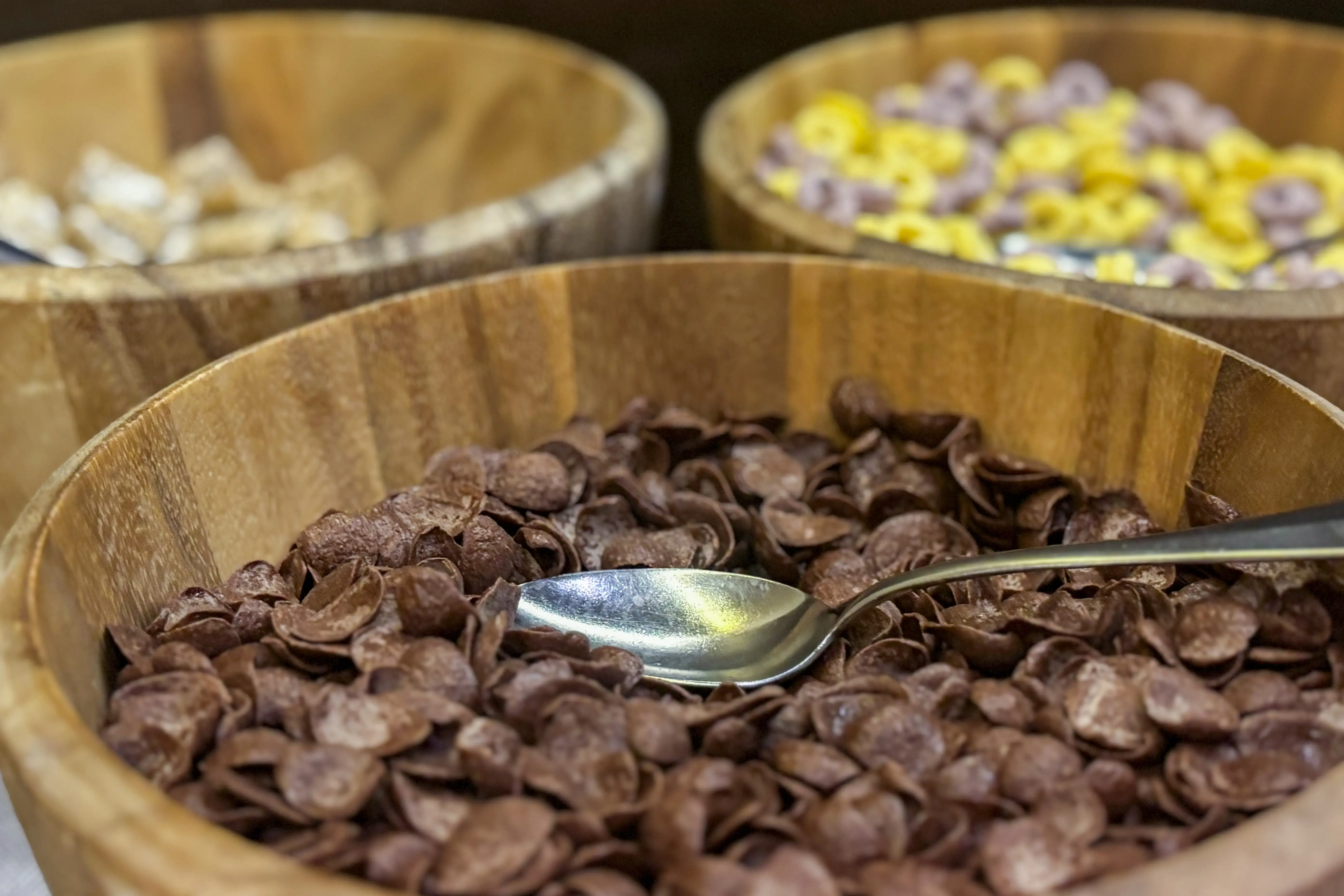 Eine Schüssel Cornflakes mit einem Löffel im Hintergrund andere Sorten Cornflakes