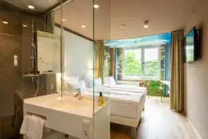 Doppelzimmer Natur Ein Zimmer mit einer Glasdusche und zwei Betten.