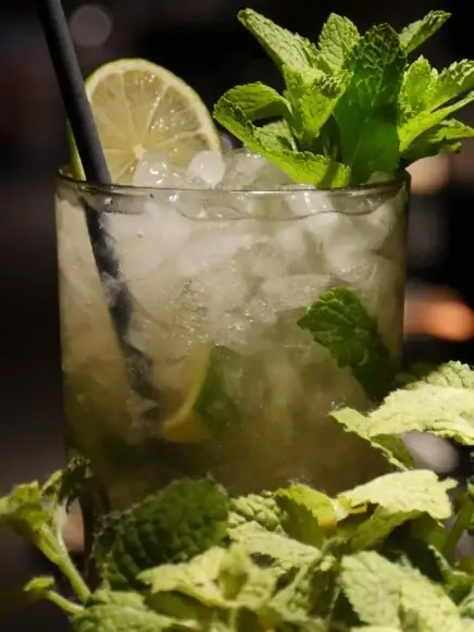 Ein Glas mit Eis und Limettengarnitur.